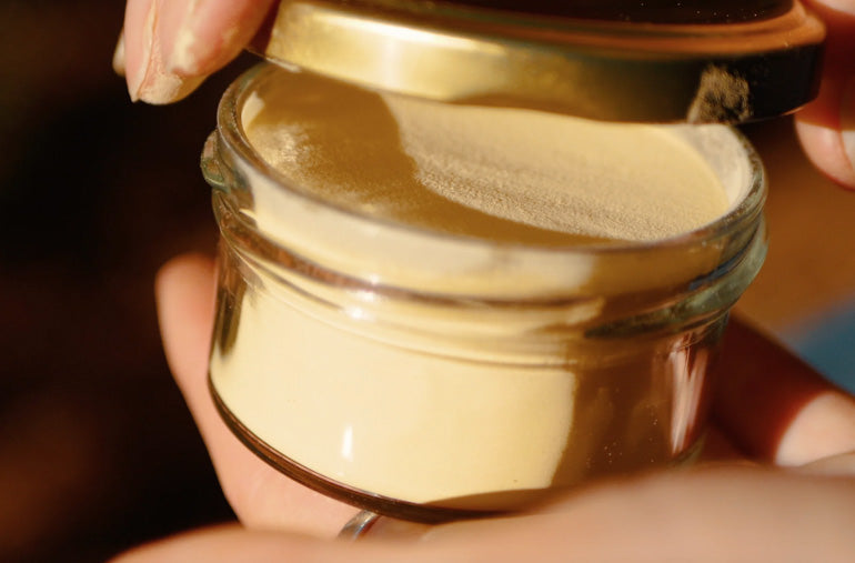 Hand holding a jar of New Zealand pine pollen